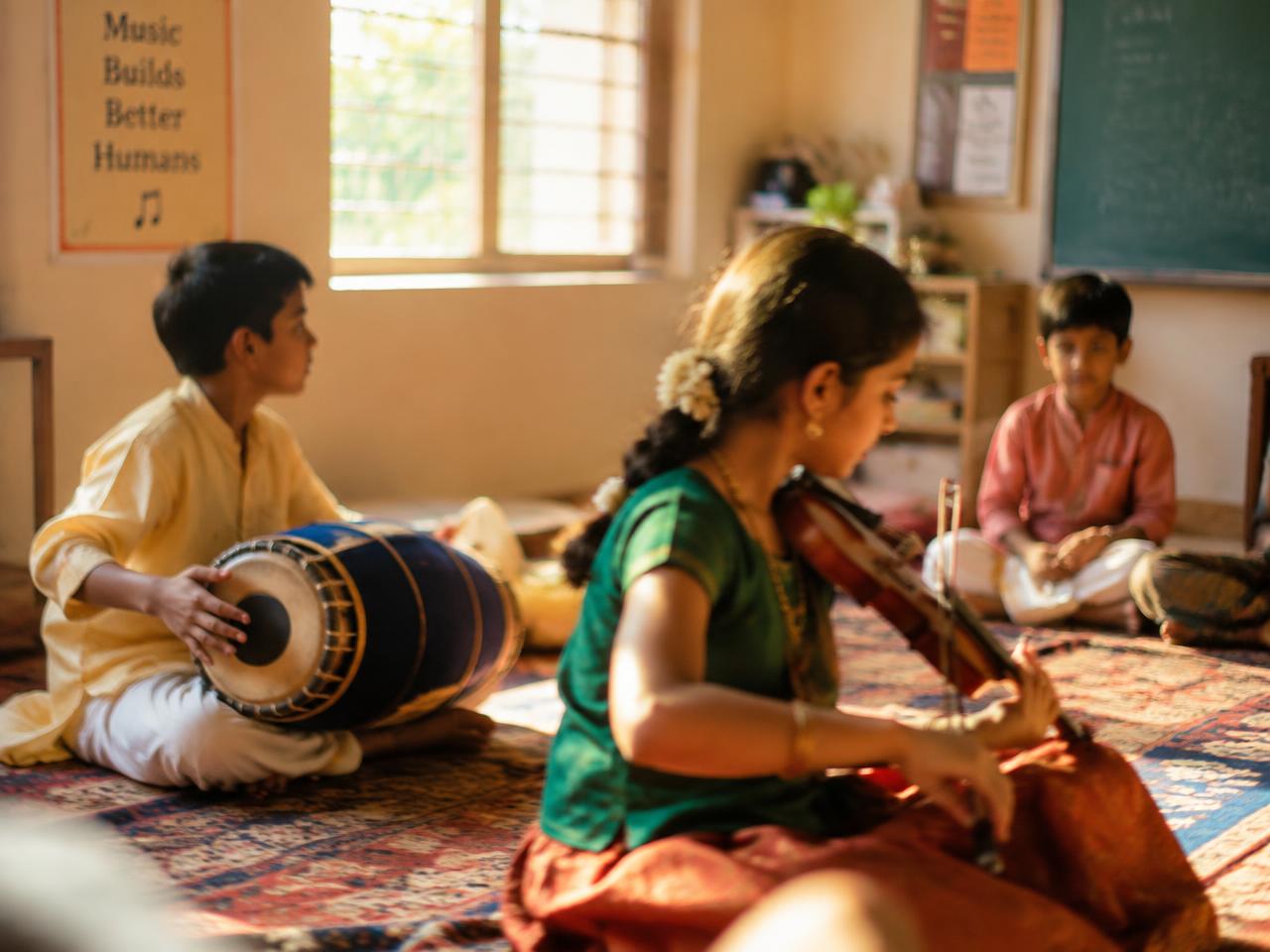 Young students practising violin and mridangam